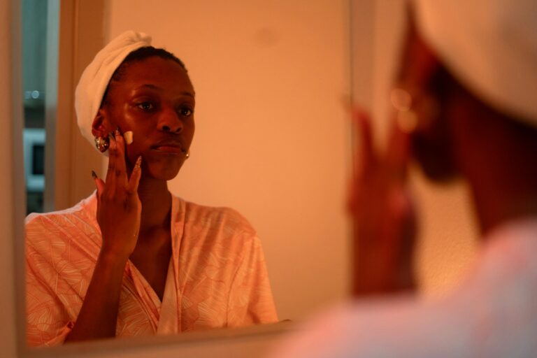 Woman applying face cream mirror
