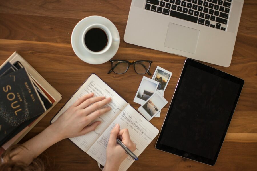 Person writing small goals notebook
