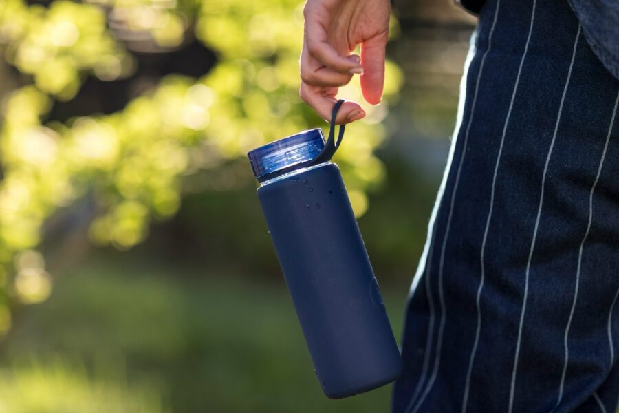 Person walking outside holding water bottle