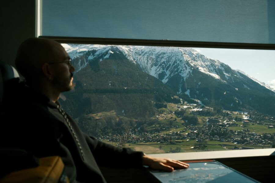 Couple sitting train looking out window mountains