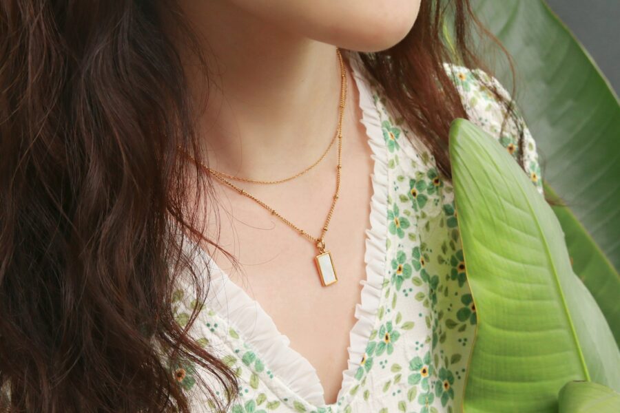 Woman layered gold necklaces linen shirt summer