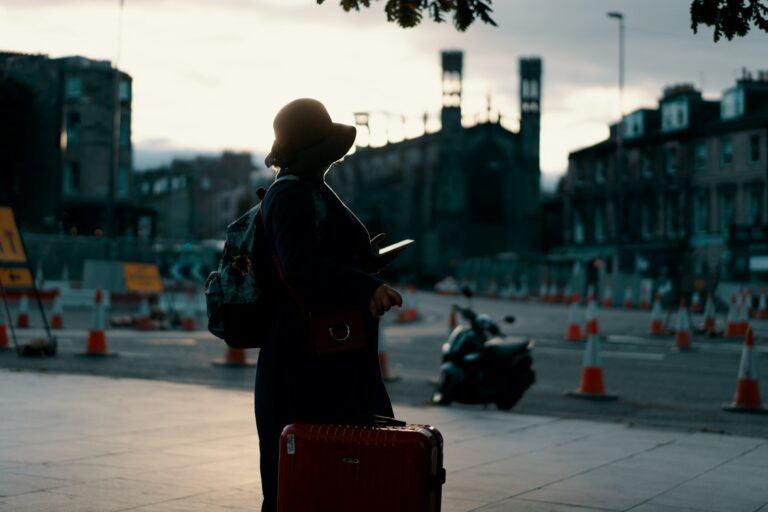 Person walking city sunset suitcase