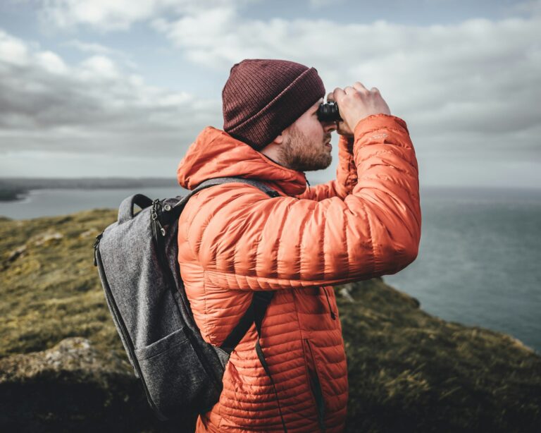 Hiker watching wild animals binoculars ethical wildlife tour