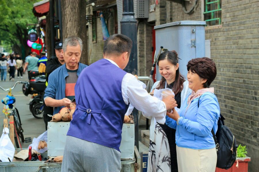 Traveler greeting local shopkeeper street market