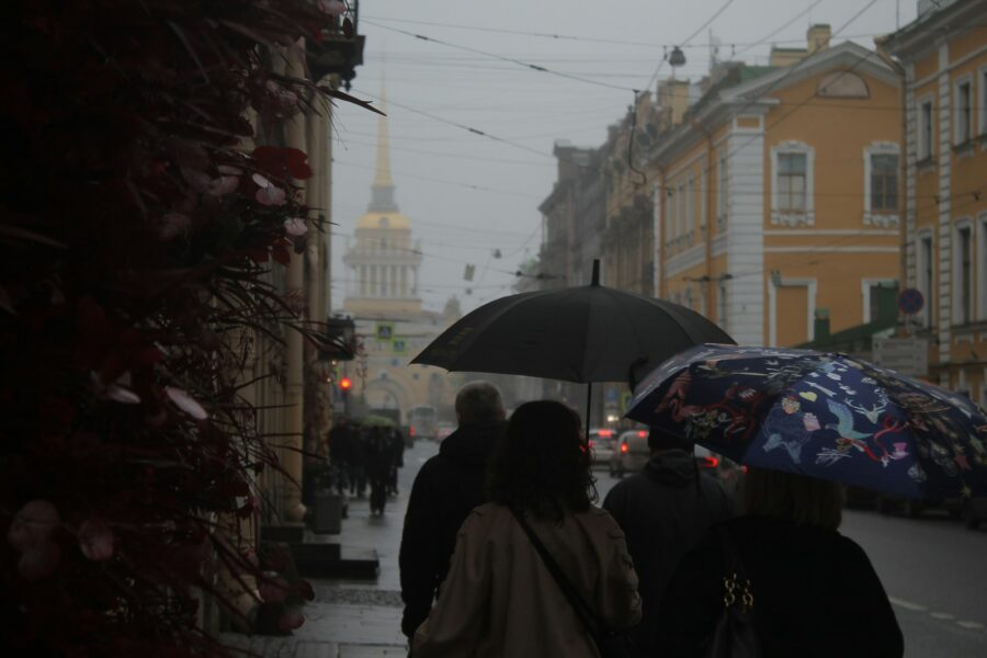 People umbrellas walking old european street rain