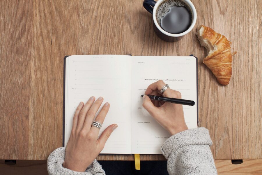Person writing identity goals journal