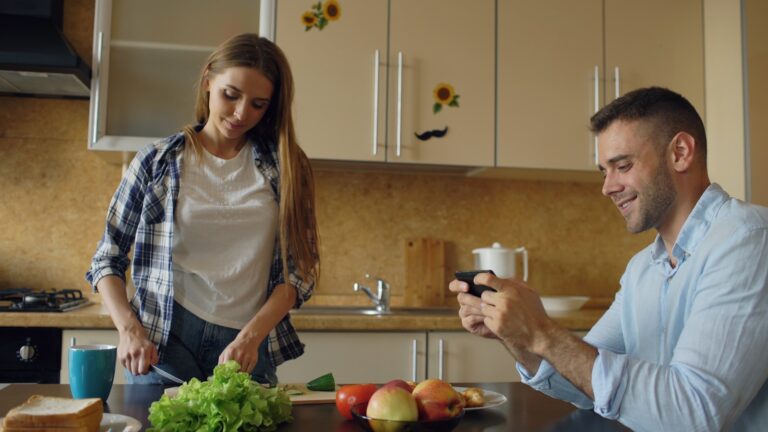Couple standing kitchen morning light hands holding mugs