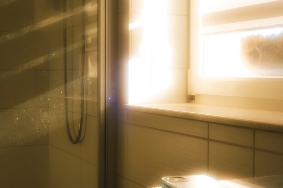 Woman applying sunscreen summer light bathroom