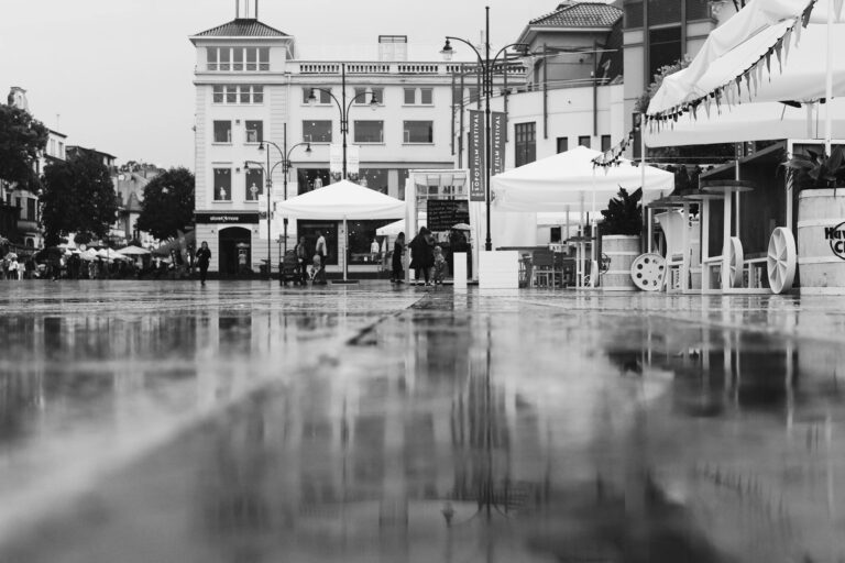 Rainy city street umbrellas reflections