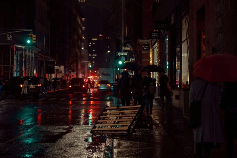 Rainy city street umbrellas reflections
