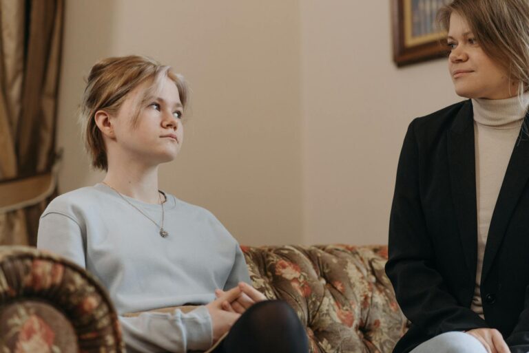 Adult daughter talking older mother sofa